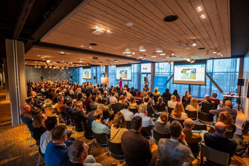 Een groep mensen die naar een presentatie kijken