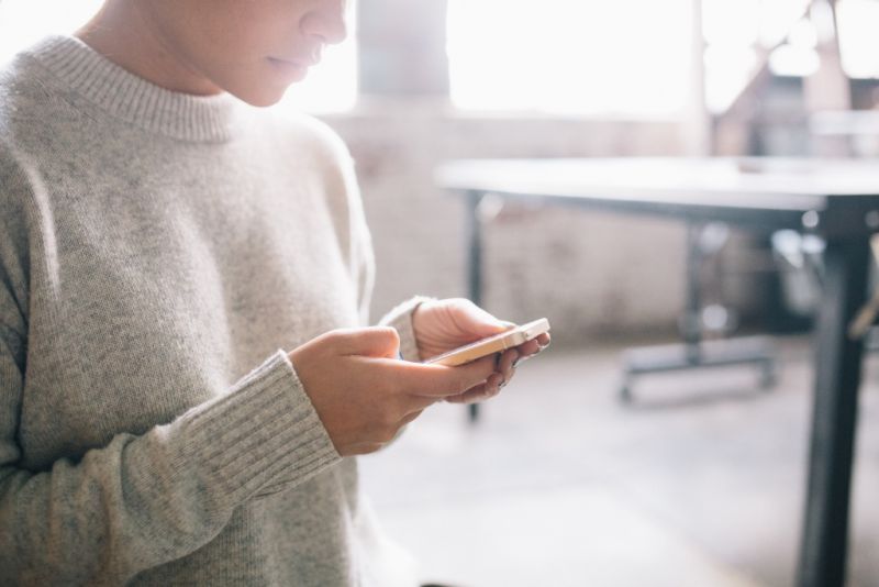 Vrouw met mobiel in haar handen