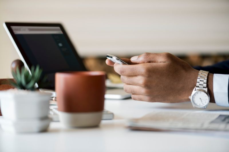Man met telefoon en laptop