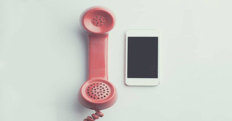 iPhone en ouderwetse telefoon op tafel